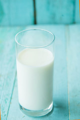 Glass of milk on wooden table and lactose free sign, on bricks wall background