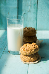A plate of peanut butter oatmeal cookies served with a cold glass of milk. These cookies are completely vegan and the milk is almond milk.
