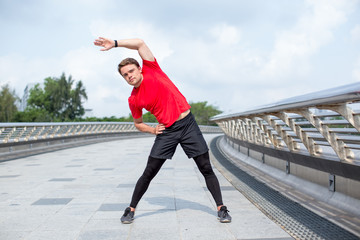 Content Young Man Doing Side Bends Outdoors