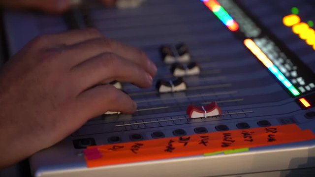 The sound engineer controls the mixer during a concert