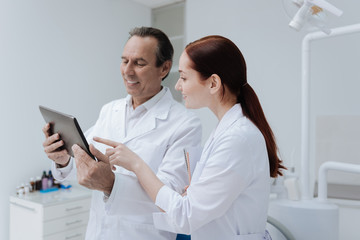 Attentive female pointing his forefinger on the tablet