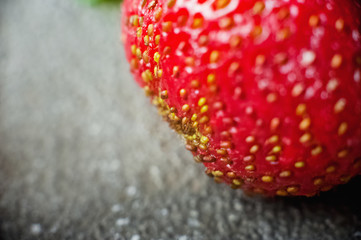 Strawberry with mint lies on a concrete gray background. Food in the macro. Strawberries with powdered sugar