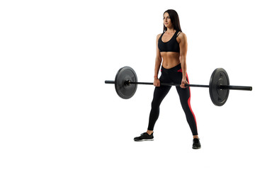 Young athletic woman doing deadlift  with barbell on white isolated background, standing in rack