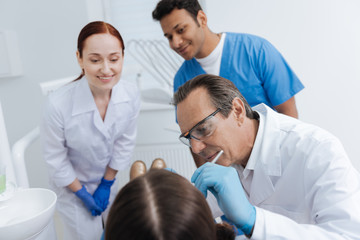 Fototapeta na wymiar Competent dentist while filling teeth