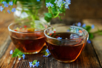 Marble cupcake and tea with flowers on a wooden background