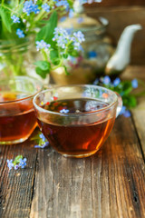 Romantic background with cup of tea ,lilac flowers and open book over white table