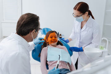 Funny patient kid smiling and looking through orange protection