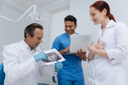 Competent stomatologist showing X-ray image