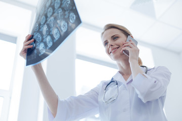 Glad radiologist analyzing brain x ray at the laboratory