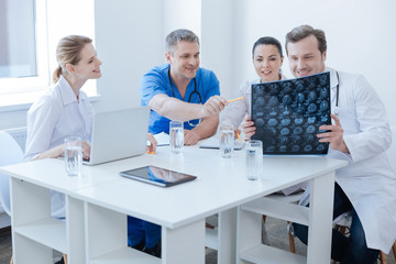 Fototapeta na wymiar Optimistic radiologists discussing brain x ray image at the laboratory
