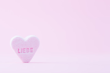 Pastel colored candy hearts in a bokeh background.