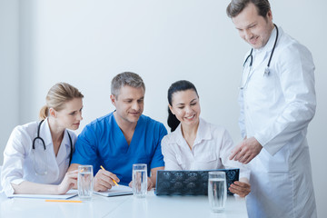 Fototapeta premium Optimistic traumatic surgeons analyzing x ray photo at the clinic