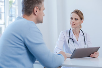 Attentive physician listen to patient complaint in the medical cabinet