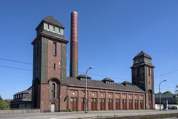 Germany, Baden-Wuerttemberg, Mannheim: Building of the Old Laundry (Alte Waescherei) with brick facade, smokestack and blue sky - obrazy, fototapety, plakaty