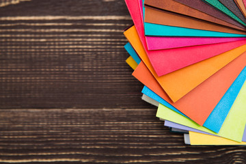  color palette  colored leather on a wooden background. Colorful upholstery fabric samples