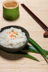 Boiled rice in a bowl on wooden table.