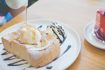 Honey toast with strawberry cake and hot coffee in cozy outdoor cafe
