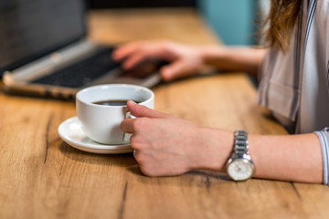  Young woman drinking coffee and working at home