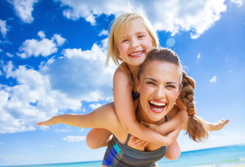 happy young mother and child on beach having fun time