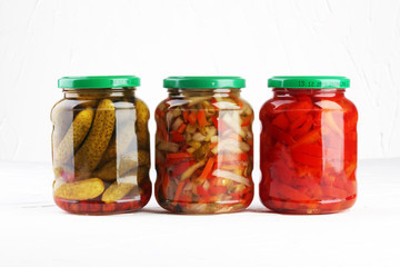 Jar with variety of pickled vegetables. Carrots, field garlic, cucumber in glas. Preserved food