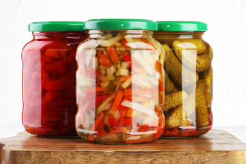 Jar with variety of pickled vegetables. Carrots, field garlic, cucumber in glas. Preserved food