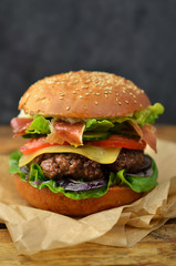 Burger with bacon on wooden table