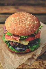 Burger with bacon on wooden table