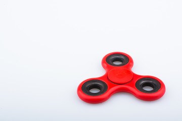 Red fidget finger spinner stress anxiety relief toy isolated on white background.