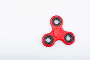 Red fidget finger spinner stress anxiety relief toy isolated on white background.