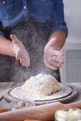 Woman baker knead and sprinkle yeast dough with eggs and flour