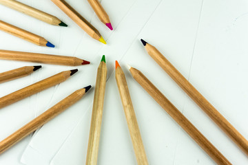 Colorful pencils on white paper as background