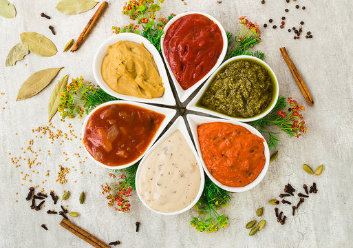 Tasty fresh sauces in a form of flower with spices on a light gray stone background. Cooking from natural components.