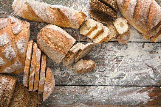 Bread bakery background. Brown and white wheat grain loaves composition on rustic wood