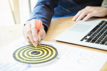 Businessman holding a darts aiming at the target center business goal concept - business targeting,...