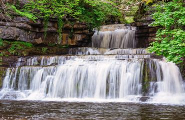 Fototapeta na wymiar Cotter Force Waterfall / Cotter Force is a small waterfall on Cotterdale Beck, a minor tributary of the River Ure, near the mouth of Cotterdale, a side dale in Wensleydale, North Yorkshire