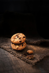 Chocolate chips cookies macro on a brown background .