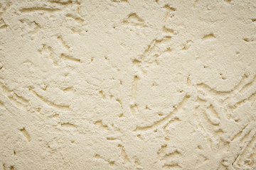 beige textured plaster on street wall of the house
