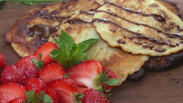 Homemade pancakes with, juicy strawberry, fresh mint and chocolate. Natural healthy food concept.