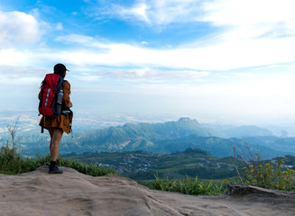 Naklejka premium Hiker woman look binoculars on the mountain, background blue sky, Thailand, select and soft focus.