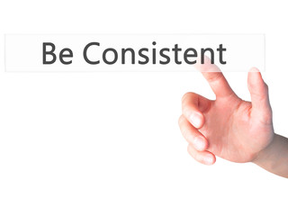 Be Consistent - Hand pressing a button on blurred background concept on visual screen.