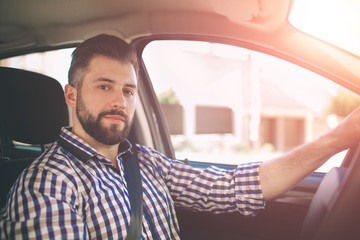 Handsome elegant serious man drives a car