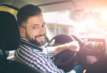 Handsome elegant serious man drives a car