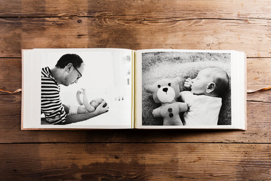 Photo album with pictures of father and baby son. Fathers day.