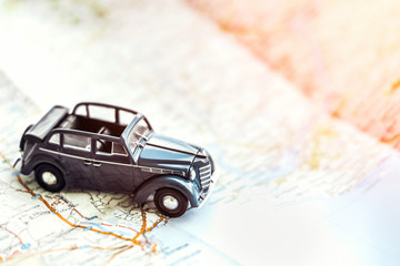Toy retro cabrio car on the map, tourism concept