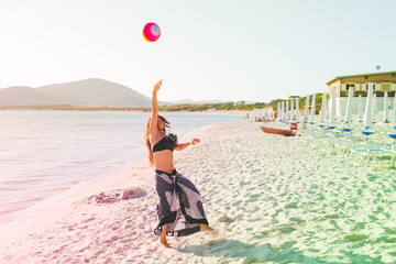 young woman playing on the beach with beach ball - summer activiities, sportive, beach sport concept