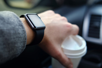 man driving a car with smart watch on his hand