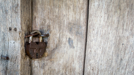 Natural material. Old metal rusty padlock, bolt on a wooden door. Old wooden brown background close-up.