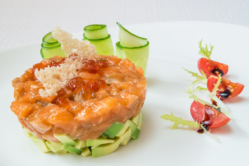 Delicious salad of fish and vegetables, tomatoes and cucumbers in the background. Horizontal frame