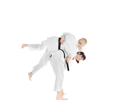 Young sporty women practicing martial arts on white background