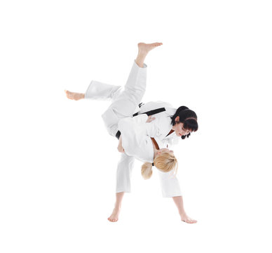 Young sporty women practicing martial arts on white background